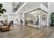 Bright living room with hardwood floors, a view of the staircase, and glass-enclosed office at 6361 Kenzie Cir, Castle Pines, CO 80108