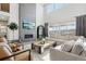 Bright living room with fireplace, large windows, and comfortable seating arrangement at 6361 Kenzie Cir, Castle Pines, CO 80108