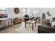 Comfortable living room with a leather sofa, accent rug, and natural light from the large windows at 6361 Kenzie Cir, Castle Pines, CO 80108
