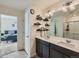 Bathroom featuring dual sinks, expansive mirror, modern lighting, and updated tile and fixtures at 2300 Mountain Sky Dr, Fort Lupton, CO 80621