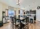 Cozy dining area featuring a rustic wooden table, stylish chairs, and views into the modern kitchen with dark cabinets at 2300 Mountain Sky Dr, Fort Lupton, CO 80621