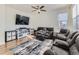 Inviting living room featuring a ceiling fan, a large window, a comfortable reclining sofa and a patterned rug at 2300 Mountain Sky Dr, Fort Lupton, CO 80621