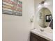 Charming powder room with neutral paint, wall decor, modern vanity and lighting at 2300 Mountain Sky Dr, Fort Lupton, CO 80621