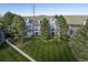 Well maintained gray townhome featuring a lush lawn and mature trees at 7452 Singing Hills Dr, Boulder, CO 80301