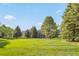 Exterior view of the community, showcasing manicured lawns and mature trees providing a park-like setting at 7452 Singing Hills Dr, Boulder, CO 80301