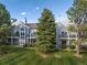 Two-story condo features balconies, landscaped lawn, mature trees and blue siding at 7452 Singing Hills Dr, Boulder, CO 80301