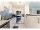 Updated kitchen features white cabinets, stainless steel appliances, granite counters, and modern backsplash at 1350 Josephine St # 307, Denver, CO 80206