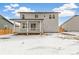 Backyard view featuring a porch and a two-story home under a cloudy sky at 15499 Kearney St, Brighton, CO 80602