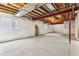 Spacious unfinished basement with white-wrapped walls and exposed ceiling beams at 15499 Kearney St, Brighton, CO 80602