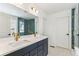 Bright bathroom featuring double sinks, blue tile shower and gold fixtures at 15499 Kearney St, Brighton, CO 80602