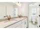 Bright bathroom featuring double sinks and gold fixtures leading to the toilet at 15499 Kearney St, Brighton, CO 80602