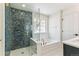 Bright bathroom featuring a tub, glass shower, and blue accent tiles with gold fixtures at 15499 Kearney St, Brighton, CO 80602