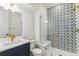 Modern bathroom featuring detailed starburst tiles in shower, and a white vanity with gold hardware at 15499 Kearney St, Brighton, CO 80602