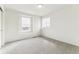 Bright bedroom featuring neutral carpet and two windows, providing lots of natural light at 15499 Kearney St, Brighton, CO 80602