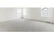 Well-lit bedroom with neutral carpet, three windows, and crisp white walls at 15499 Kearney St, Brighton, CO 80602
