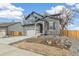 A beautiful two-story home with a stone facade and a lovely, spacious front yard at 15499 Kearney St, Brighton, CO 80602