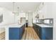Bright kitchen featuring a navy blue island, white cabinets, marble countertops, and stainless steel appliances at 15499 Kearney St, Brighton, CO 80602