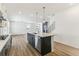 Kitchen featuring a navy blue island, white cabinets, marble countertops, stainless appliances, and herringbone backsplash at 15499 Kearney St, Brighton, CO 80602