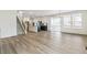 Open concept living space with hardwood floors, bright lighting, island and staircase at 15499 Kearney St, Brighton, CO 80602