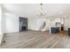 Open-concept living area with hardwood floors, fireplace, island and staircase at 15499 Kearney St, Brighton, CO 80602