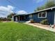 Landscaped backyard features a well-maintained lawn, garden with brick trim, and blue siding at 10130 W 20Th Ave, Lakewood, CO 80215