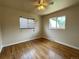 Bright bedroom features hardwood floors, neutral walls, two windows, and a ceiling fan at 10130 W 20Th Ave, Lakewood, CO 80215