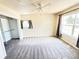 Bedroom with neutral carpet, large window, ceiling fan and open closet offers a comfortable living space at 10130 W 20Th Ave, Lakewood, CO 80215