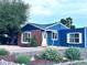 Charming home featuring blue siding, brick accents, mature landscaping, and a well-maintained front yard at 10130 W 20Th Ave, Lakewood, CO 80215