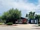 Charming single-story home with brick and navy siding, surrounded by mature trees and landscaping at 10130 W 20Th Ave, Lakewood, CO 80215