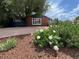 Well-maintained front yard boasting a mix of mulch, river rock, and blossoming white flowers at 10130 W 20Th Ave, Lakewood, CO 80215