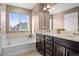 Bright bathroom features a soaking tub, double sink vanity with a dark cabinet at 11440 E 26Th Ave, Aurora, CO 80010