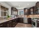 Modern kitchen with dark wood cabinets, stainless steel appliances, and updated tile backsplash at 1011 Pierce St # 11, Lakewood, CO 80214