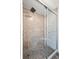 Modern shower features stone pebble floor, tiled walls, seating and frameless glass door at 1011 Pierce St # 11, Lakewood, CO 80214