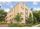 A low angle side view of the building showing brick exterior and surrounding trees and landscaping at 10 N Ogden St # 5, Denver, CO 80218