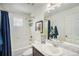 Well-lit bathroom with a tub, white tile, marble countertop, and a decorative window, combining style and functionality at 5325 Ventura St, Denver, CO 80249