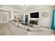 Comfortable living room with a large TV, modern decor, and an open view into other rooms at 5325 Ventura St, Denver, CO 80249