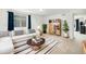 Bright living room with white couch, striped rug, plants, and wooden bookshelf, creating a cozy and inviting space at 5325 Ventura St, Denver, CO 80249