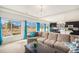 Open-concept living room with large windows, blue curtains, and view to the kitchen at 5325 Ventura St, Denver, CO 80249