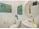 Chic powder room with modern art, oval mirror, floating sink, and a pop of color, maximizing style in a compact space at 5325 Ventura St, Denver, CO 80249