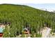 Scenic aerial view featuring the charming cabin situated on a tree-covered hillside, offering a secluded retreat at 489 Harris Dr, Idaho Springs, CO 80452