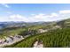 Panoramic aerial view of a mountain town nestled in a lush forest with snowy peaks in the distance at 489 Harris Dr, Idaho Springs, CO 80452