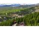 Scenic aerial view of the property nestled in the mountains with snow-capped peaks in the background at 489 Harris Dr, Idaho Springs, CO 80452