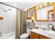 Bathroom with shower-tub, wooden finishes, window, and sink featuring a vintage-inspired aesthetic at 489 Harris Dr, Idaho Springs, CO 80452