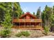 Charming cabin with a spacious, multi-level deck offering stunning views of the surrounding forest at 489 Harris Dr, Idaho Springs, CO 80452