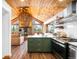 Spacious kitchen and living area featuring rustic wood ceiling, stone fireplace and views of the outdoors at 489 Harris Dr, Idaho Springs, CO 80452