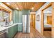 Well-lit kitchen with stainless steel refrigerator and view into bedroom, enhancing the home's open layout at 489 Harris Dr, Idaho Springs, CO 80452