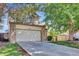 Two-story home with attached two car garage, mature landscaping, and manicured lawn at 15941 Bluebonnet Dr, Parker, CO 80134