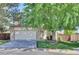 Charming front exterior featuring a lush lawn, mature tree, and an attached two-car garage at 15941 Bluebonnet Dr, Parker, CO 80134