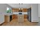 Bright kitchen with oak cabinets, center island, and sleek black appliances at 15941 Bluebonnet Dr, Parker, CO 80134