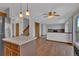 Open-concept living space with kitchen, brick fireplace, and hardwood floors at 15941 Bluebonnet Dr, Parker, CO 80134